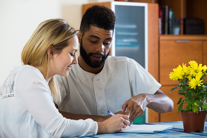 Man and woman at a table looking at a paper document